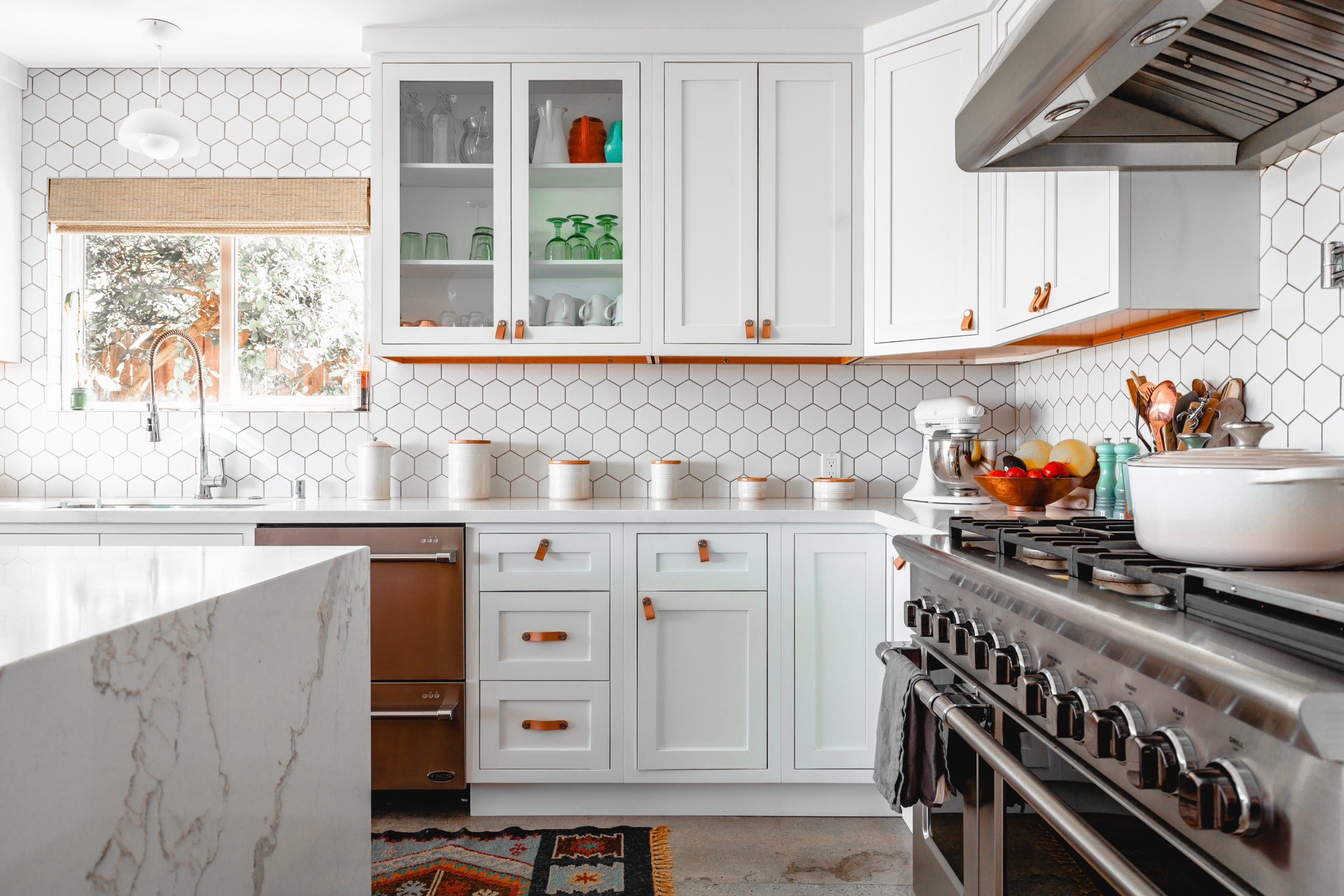 White kitchen design with touch of orange hardware