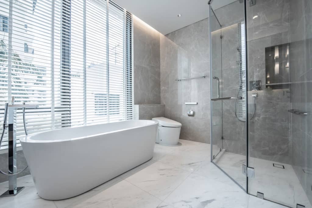 grey bathroom design with bath tub, toilet and shower for bathroom remodeling