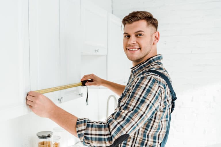 men measuring kitchen cabinets