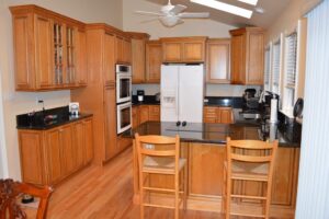 21st Century Maple Traditional kitchen cabinets with black countertops