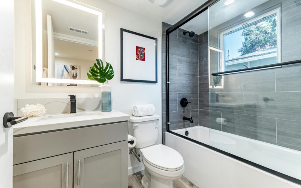 Modern small bathroom remodeling with tub, vanity, and toilet