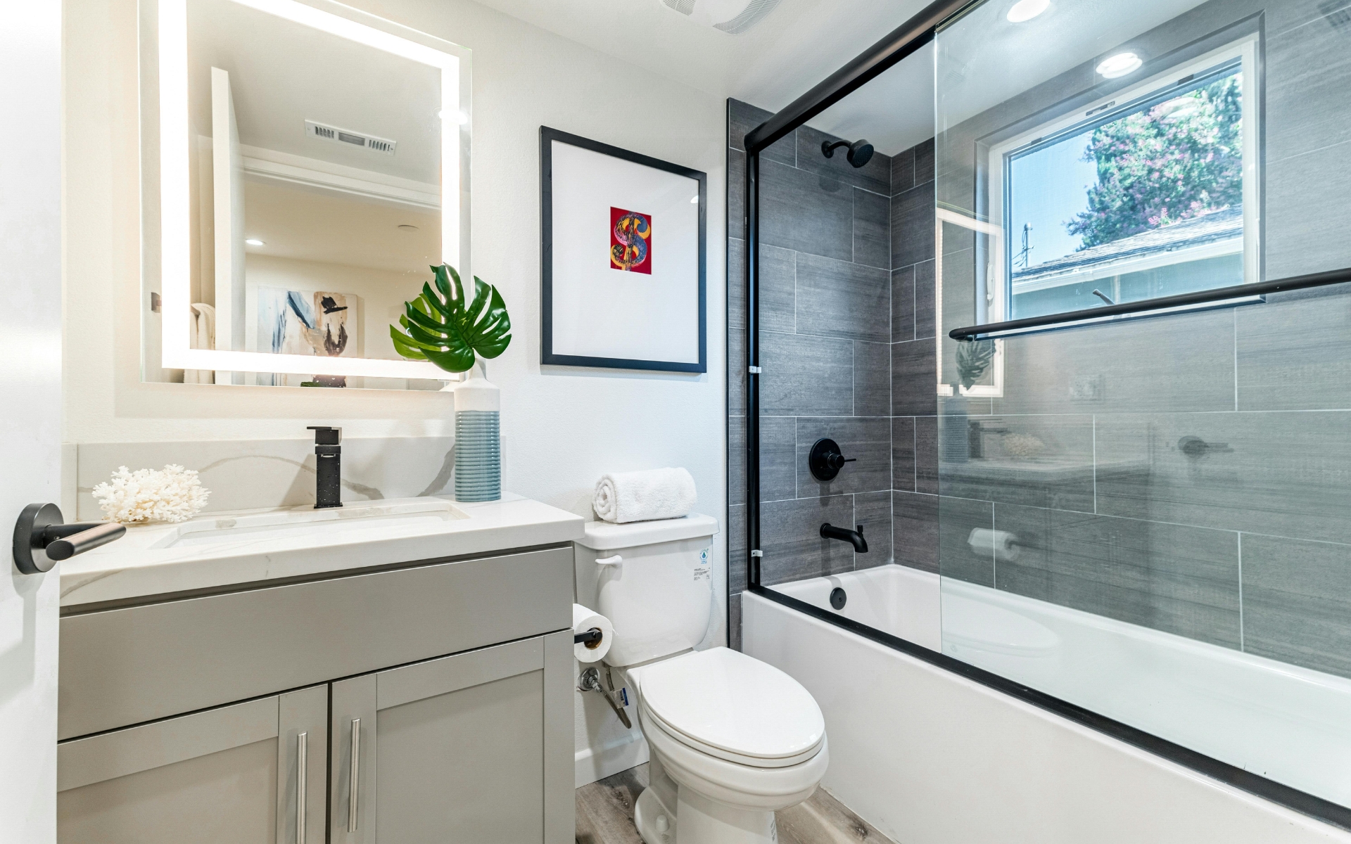 Modern small bathroom remodeling with tub, vanity, and toilet