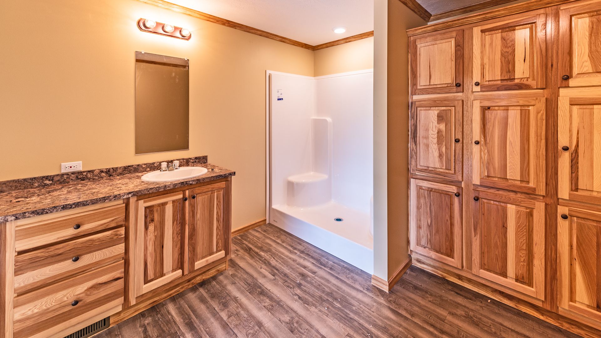 Rustic bathroom style with wood bathroom cabinets and walk in shower