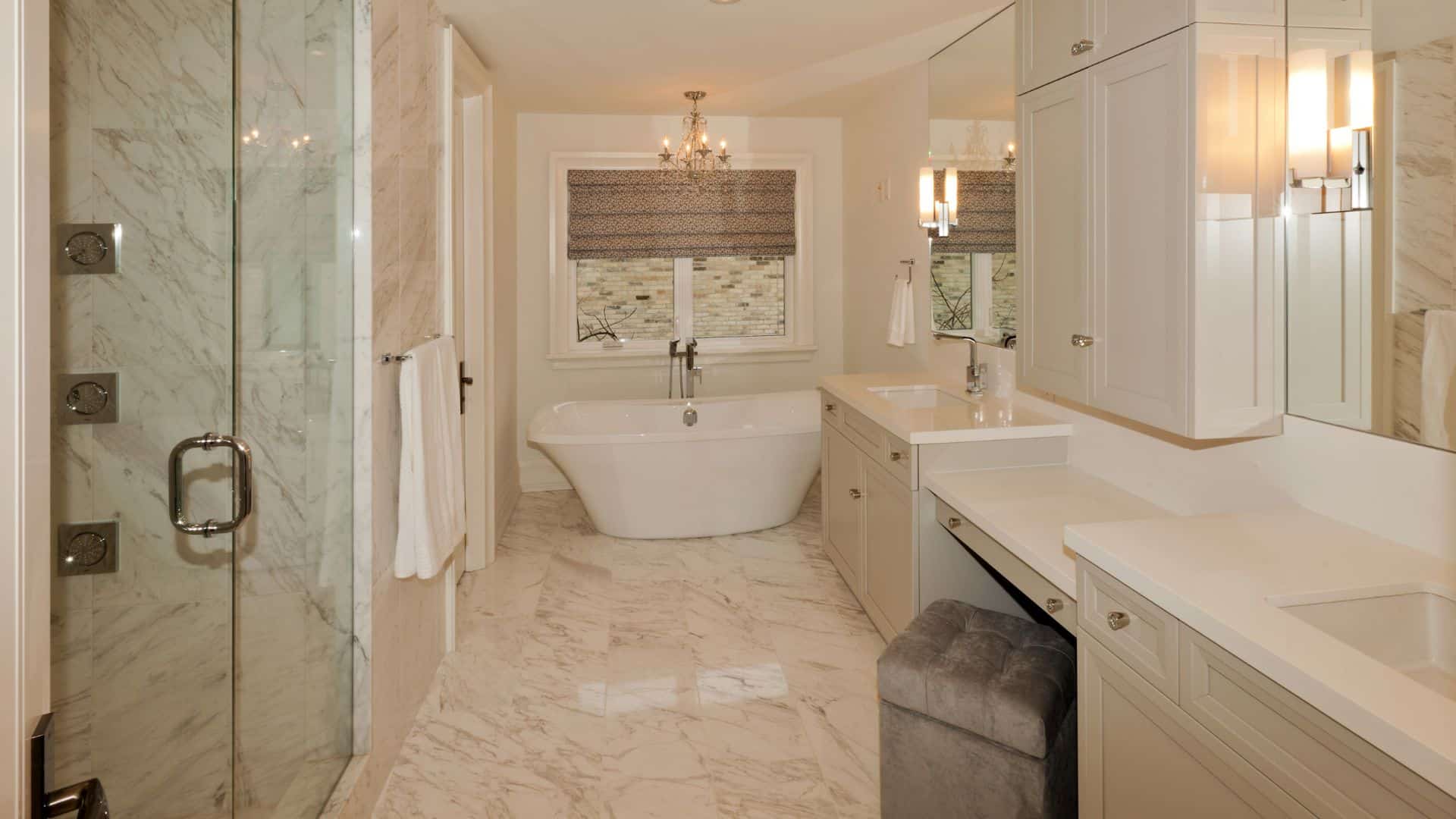 Elegant cream bathroom with cream bathroom cabinets, bath tub and a shower
