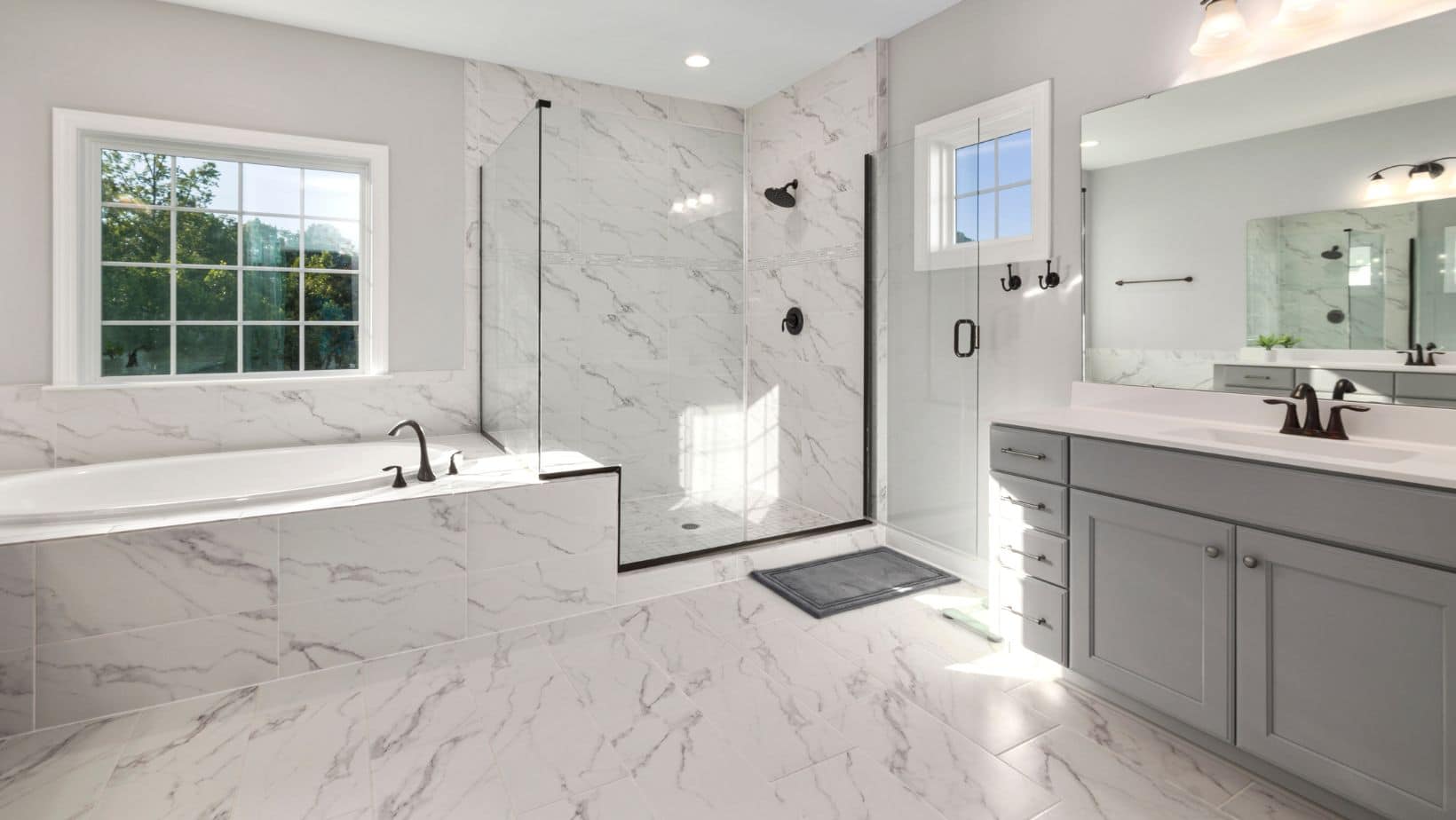 Luxury white bathroom with bath tub, shower and grey bathroom cabinets with white countertop