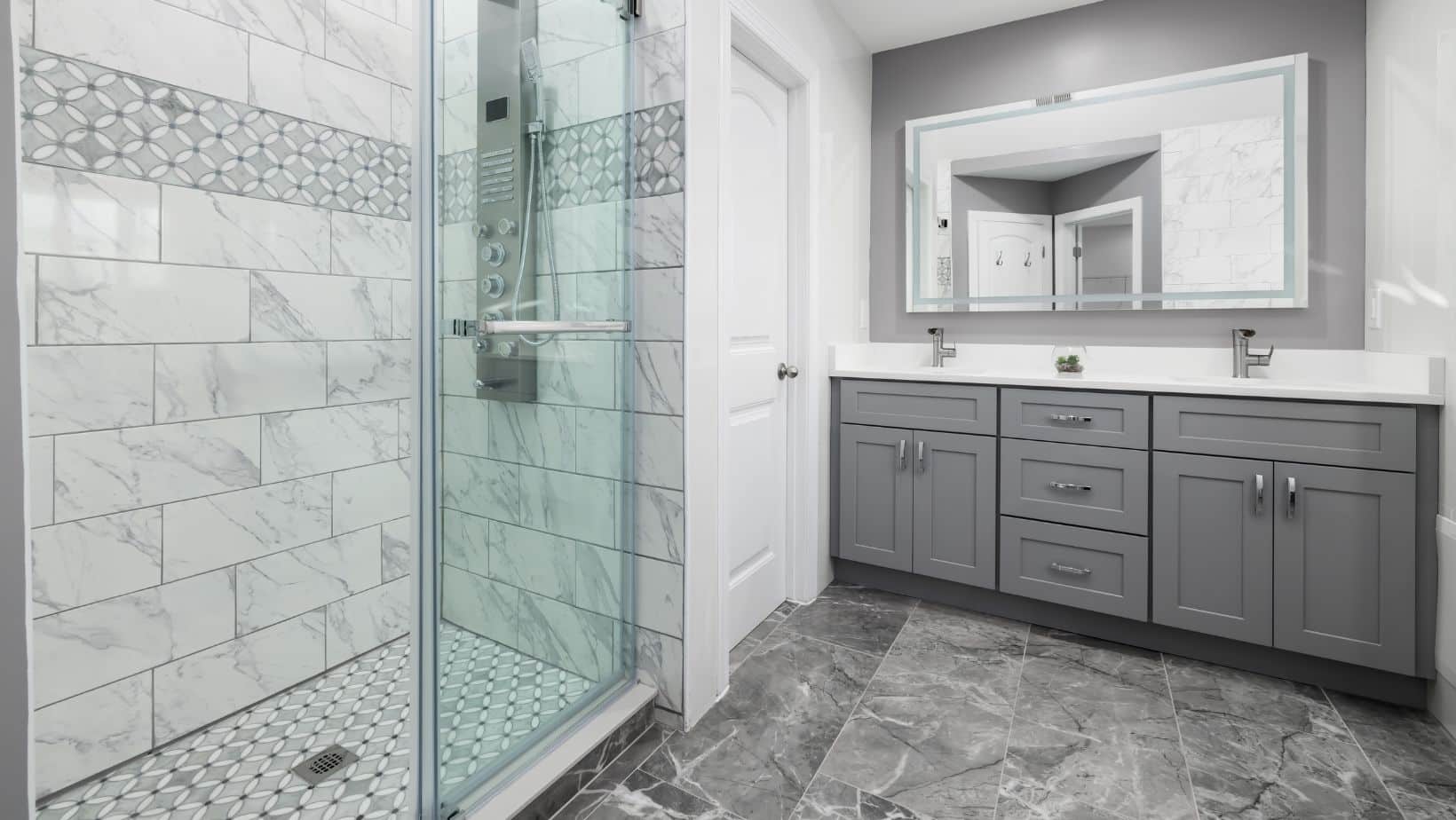 Small white bathroom with shower and grey bathroom cabinets with white countertop