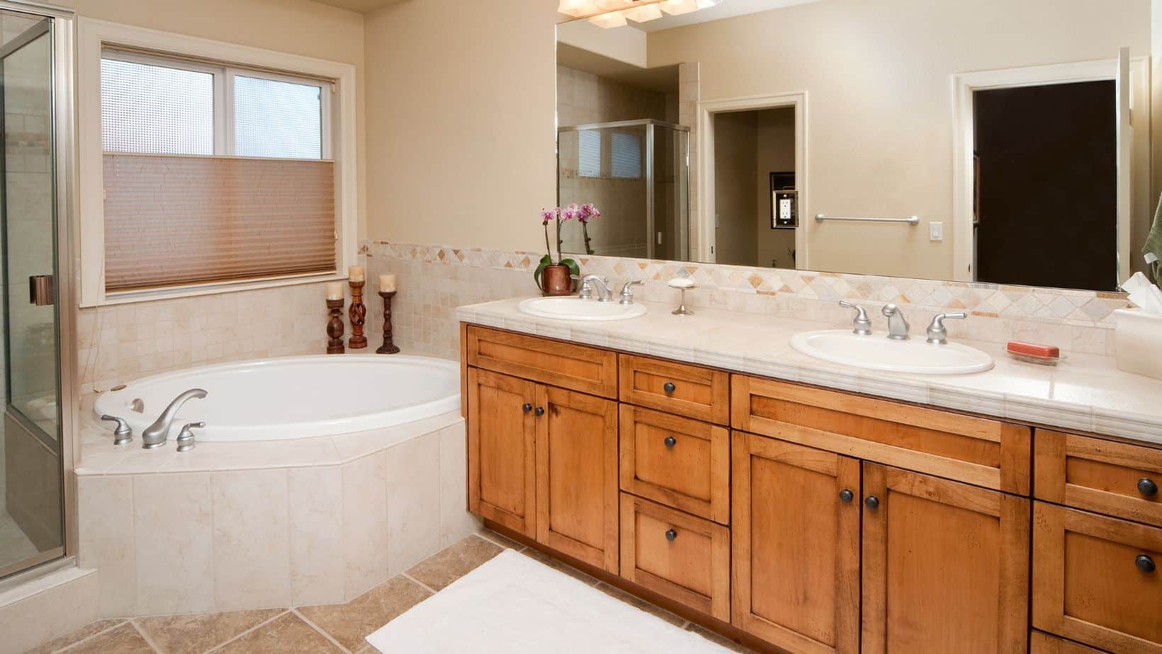 Traditional bathroom style with brown bathroom cabinets and bath tub