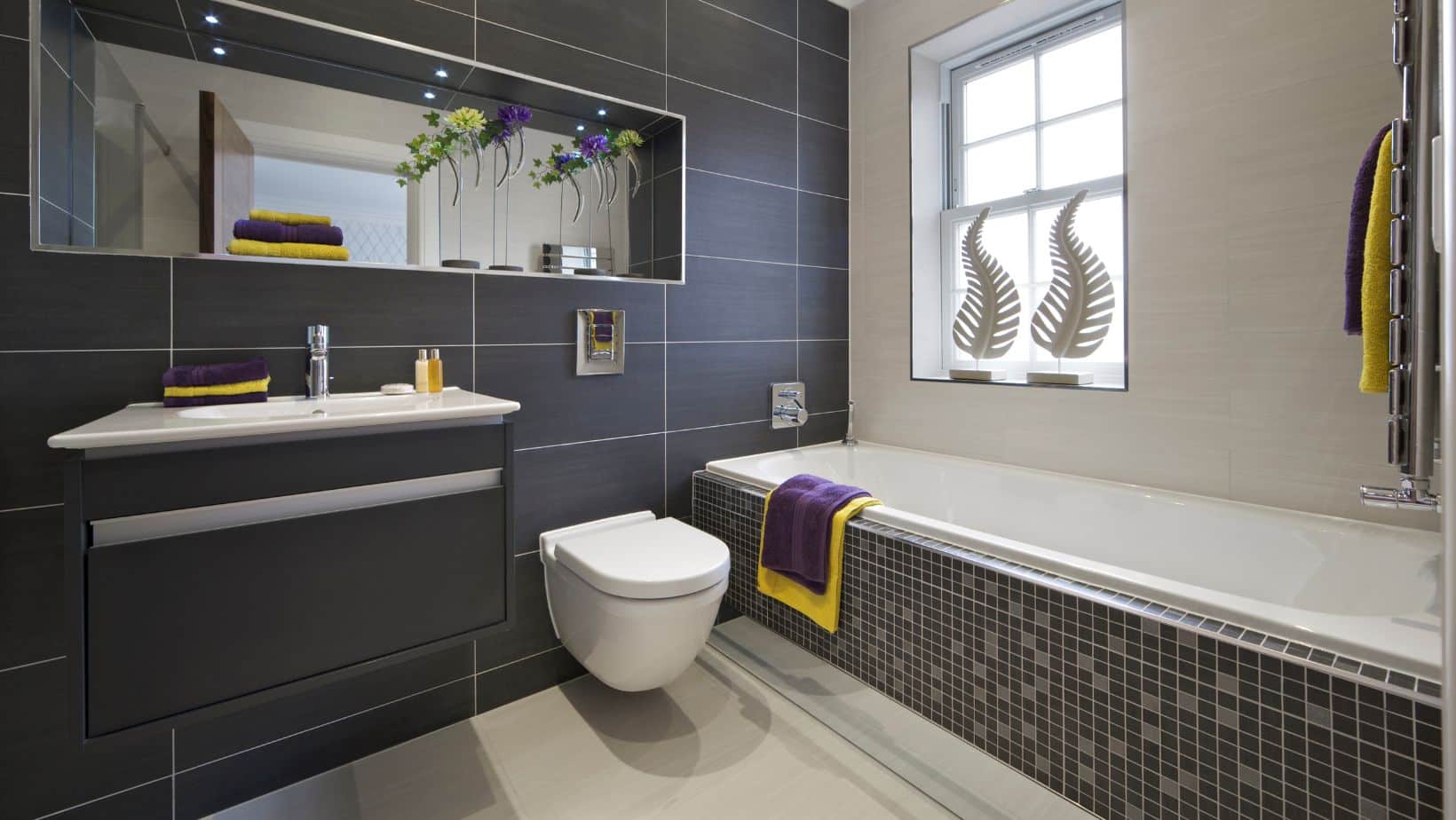 Black small bathroom with black floating cabinet, toilet and bath tub