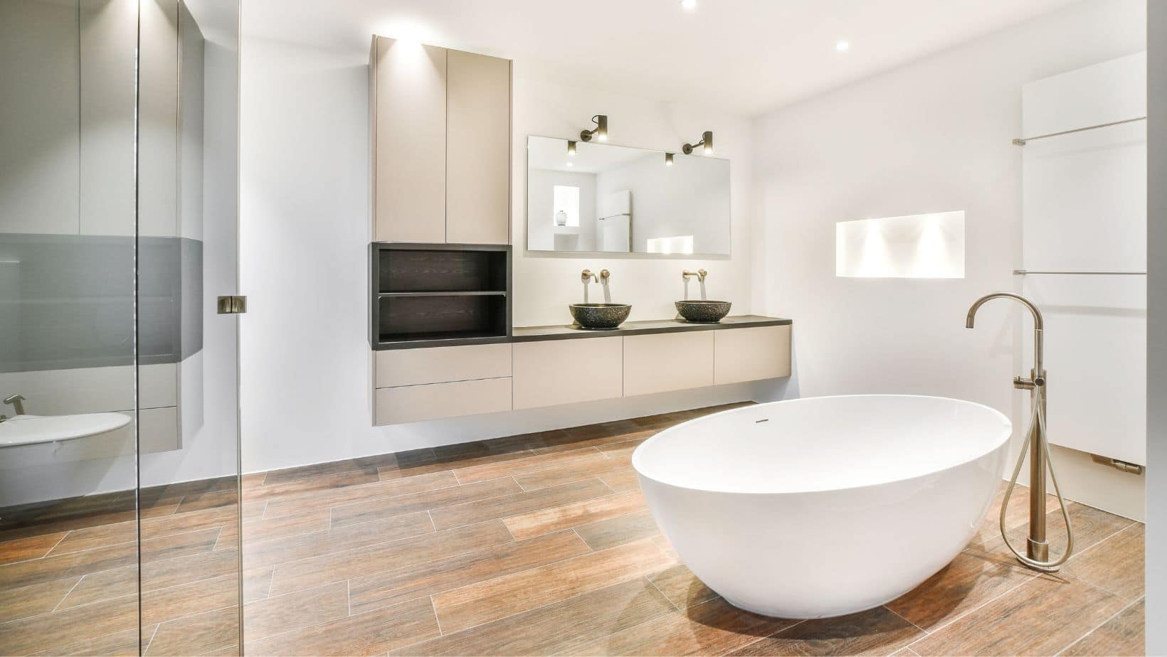 Spacious modern bathroom style with cream floating vessel sink cabinets and a bath tub.
