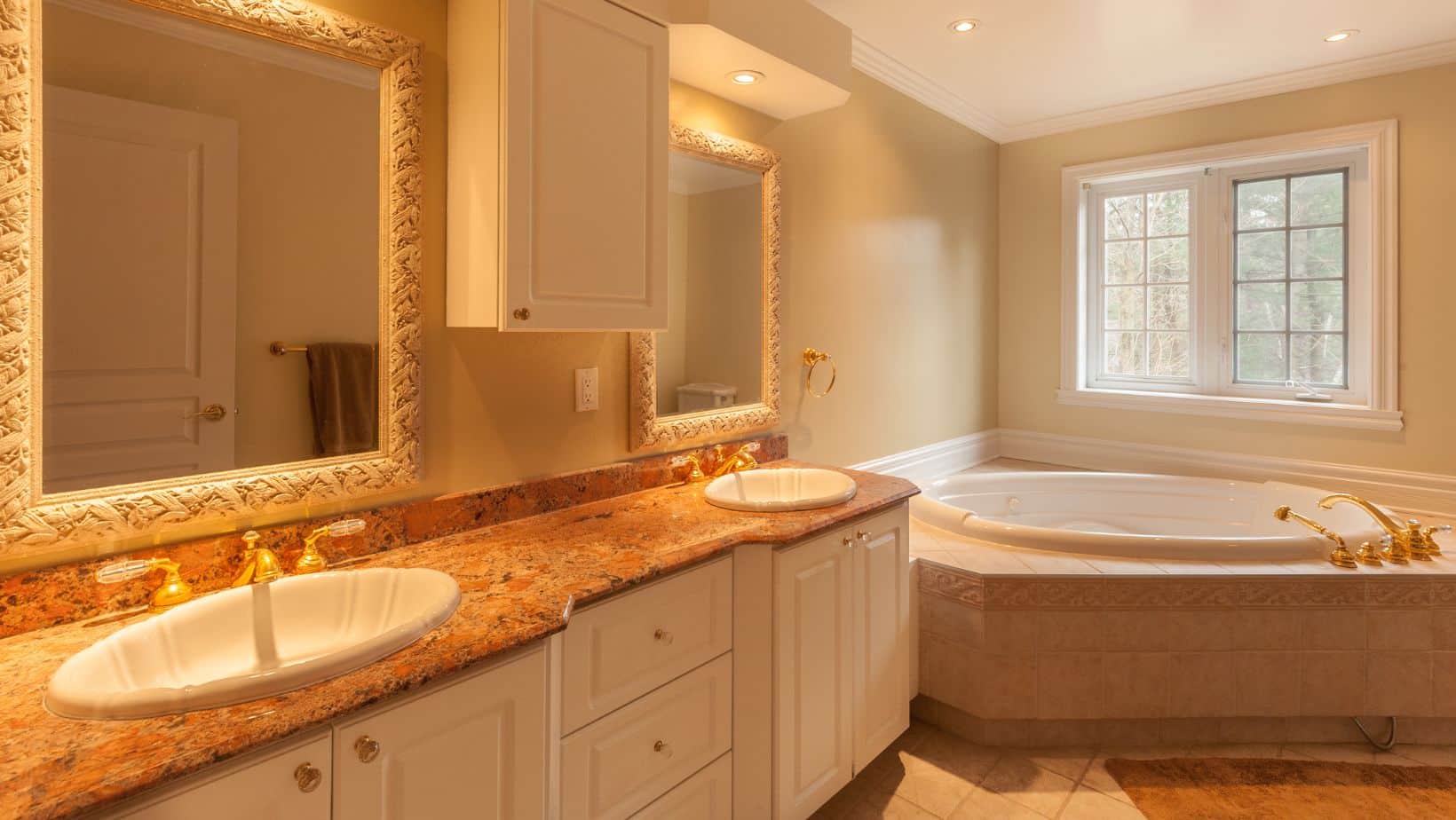 Luxury bathroom with cream double sink bathroom cabinets, and bath tub