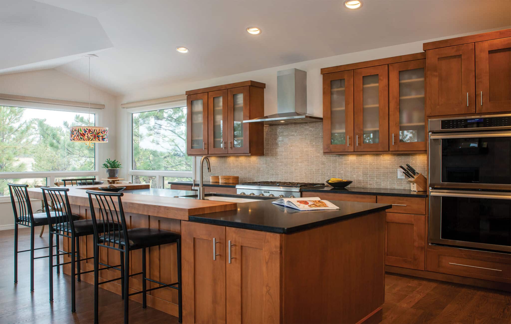 Woodharbor brown kitchen cabinets with black countertops