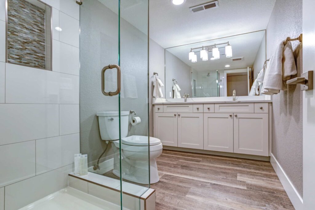 Medium sized bathroom with shower, toilet, and white bathroom vanity