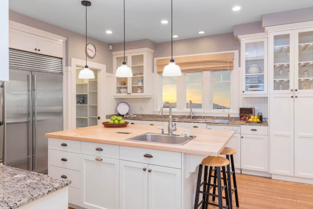 White and cream kitchen design with elegant lighting and shaker cabinets