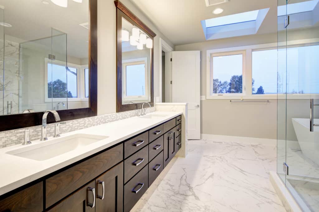 Bright and airy master bathroom features White Modern Double Vanity With Rich Brown Cabinets accented with mosaic backsplash and paired with marble floor.