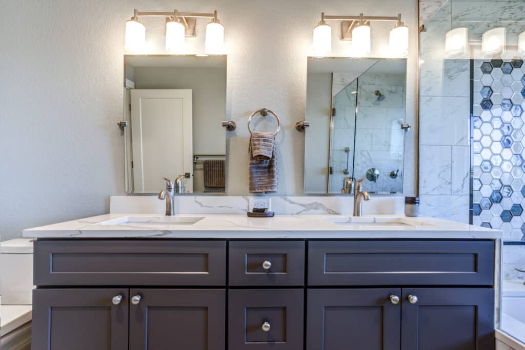 Zoomed in photo of dark brown shaker double-sink vanity with white marble countertop