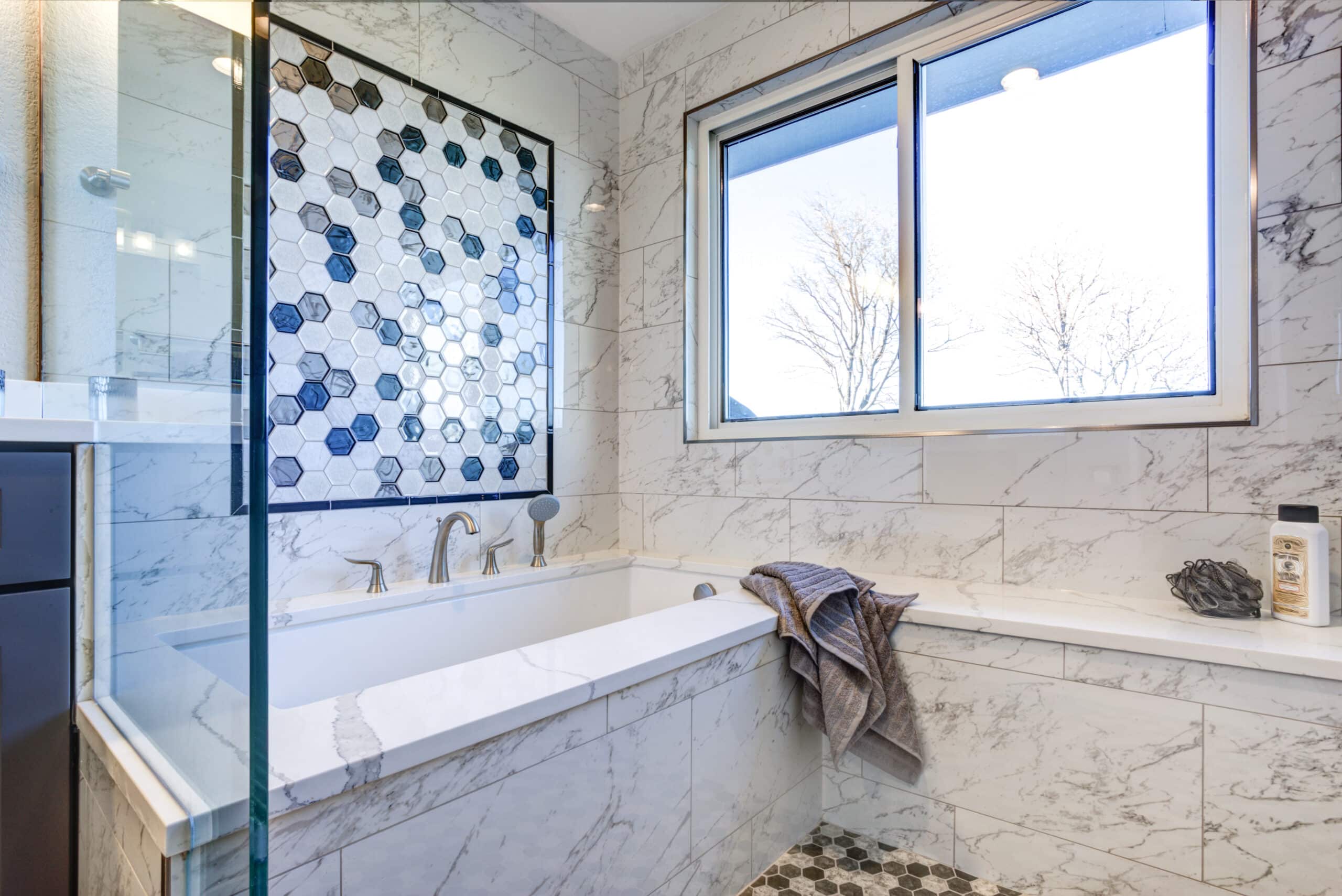 Luxury bathroom with Marble tile Surround and mosaic accent wall.
