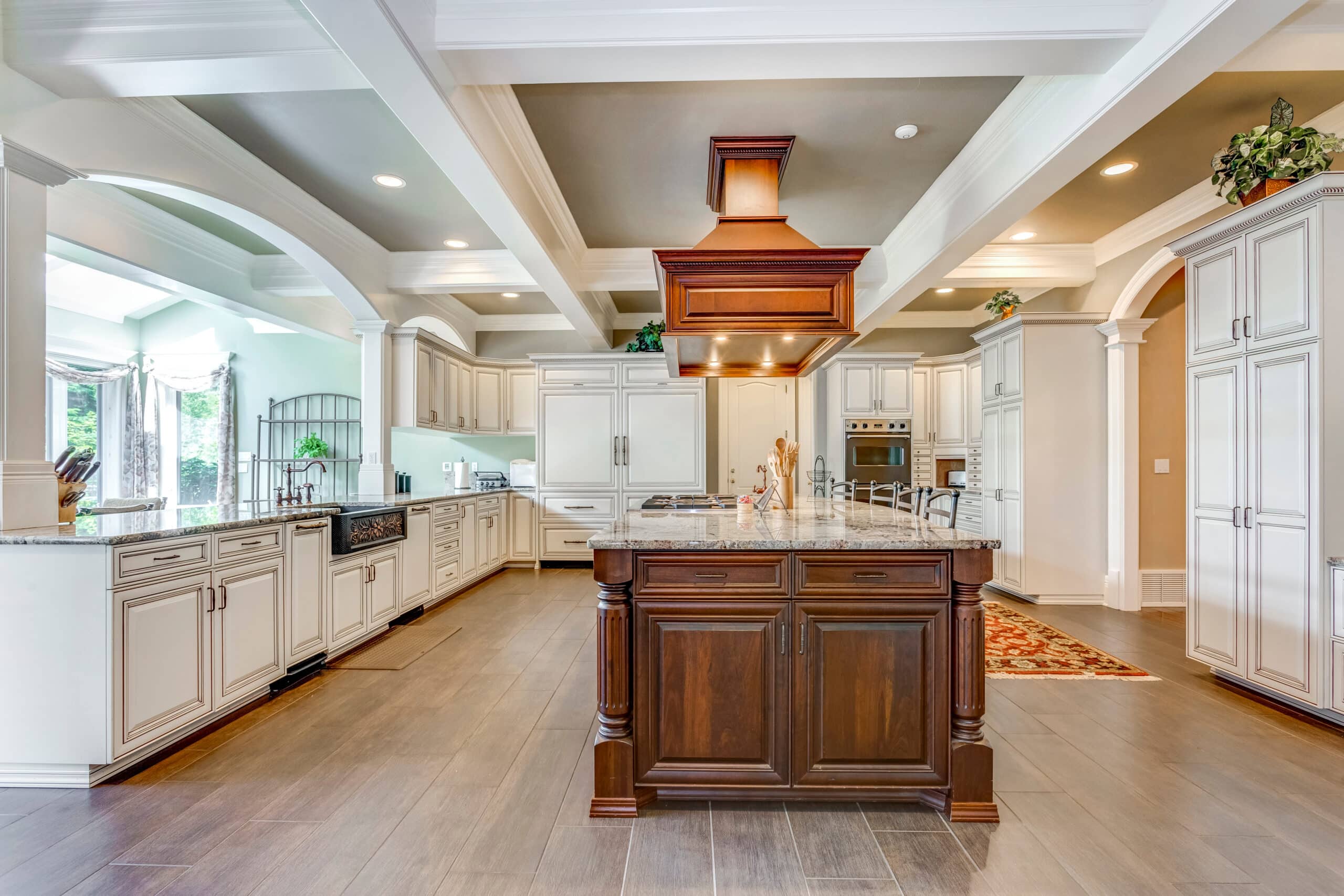 Stunning kitchen room design with large bar style island and coffered ceiling.
