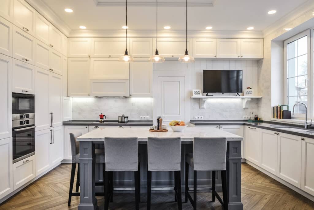 White kitchen design with white shaker cabinets and white countertop on kitchen island