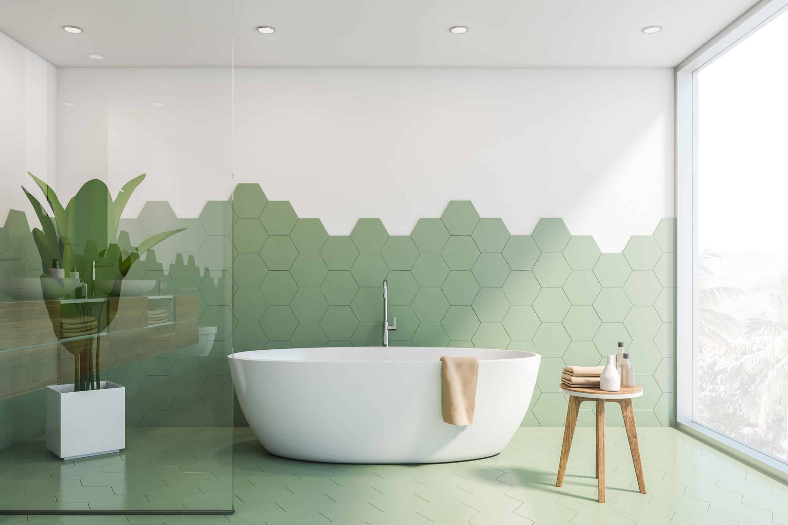 Interior of stylish bathroom with green hexagonal tile and white walls, panoramic window and comfortable white bathtub with towel on it. 3d rendering