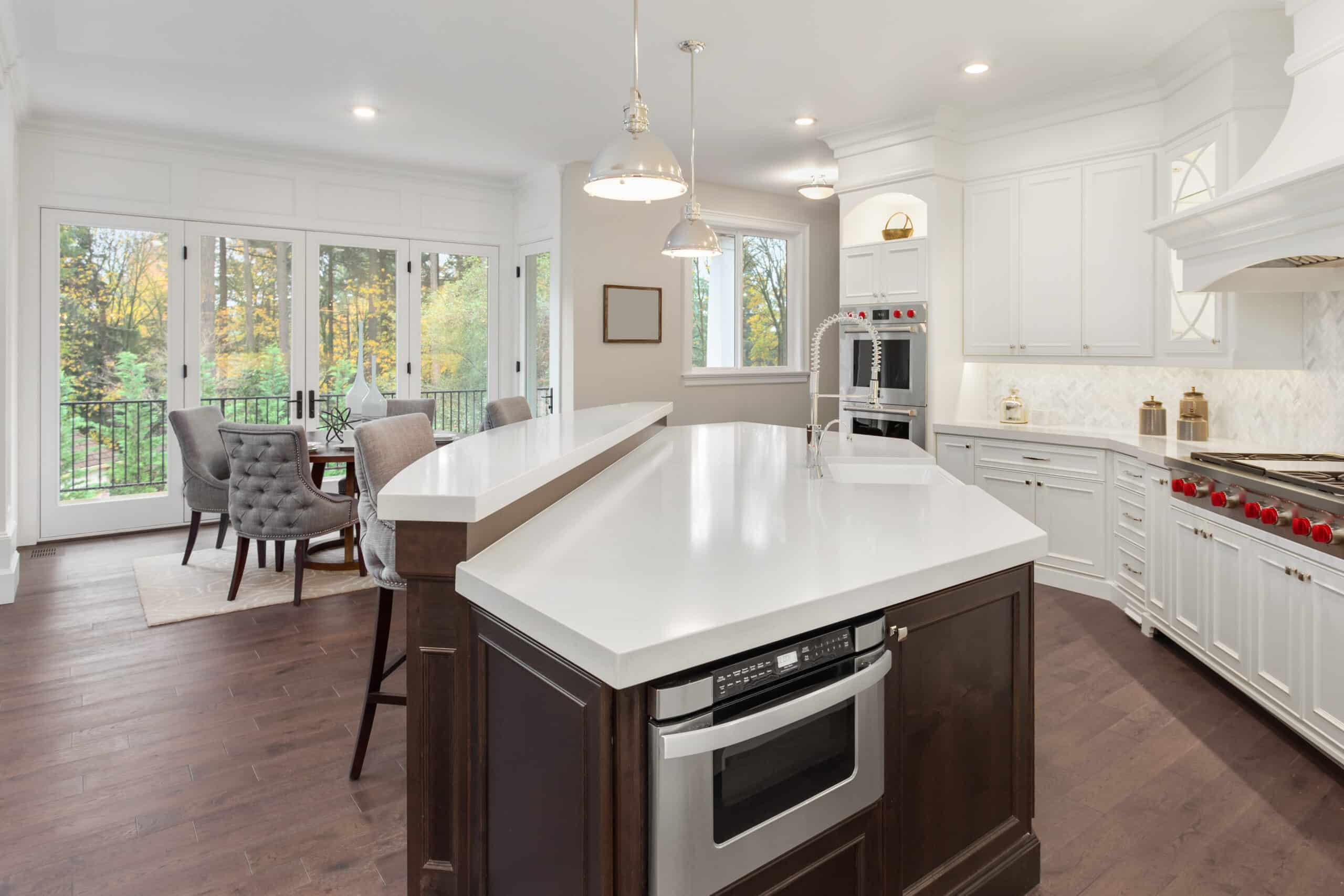 Beautiful kitchen in new luxury home with hardwood floors, white cabinets, and quartz countertops. Shows eating nook.