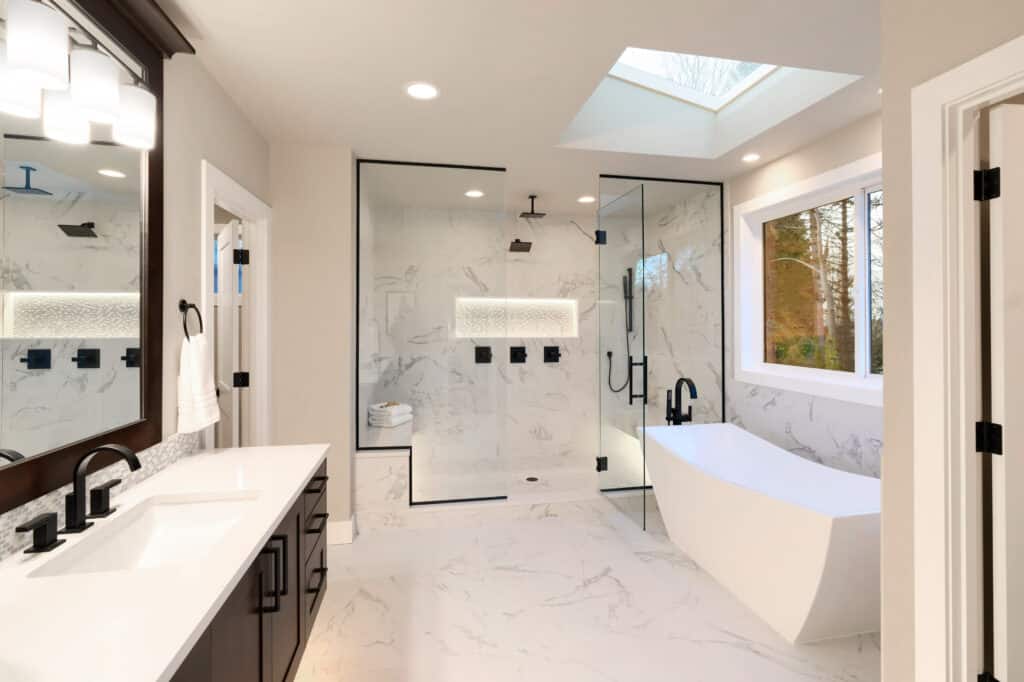White Kitchen Bathroom with luxury bath tub, shower and vanity, surrounded by porcelain tiles