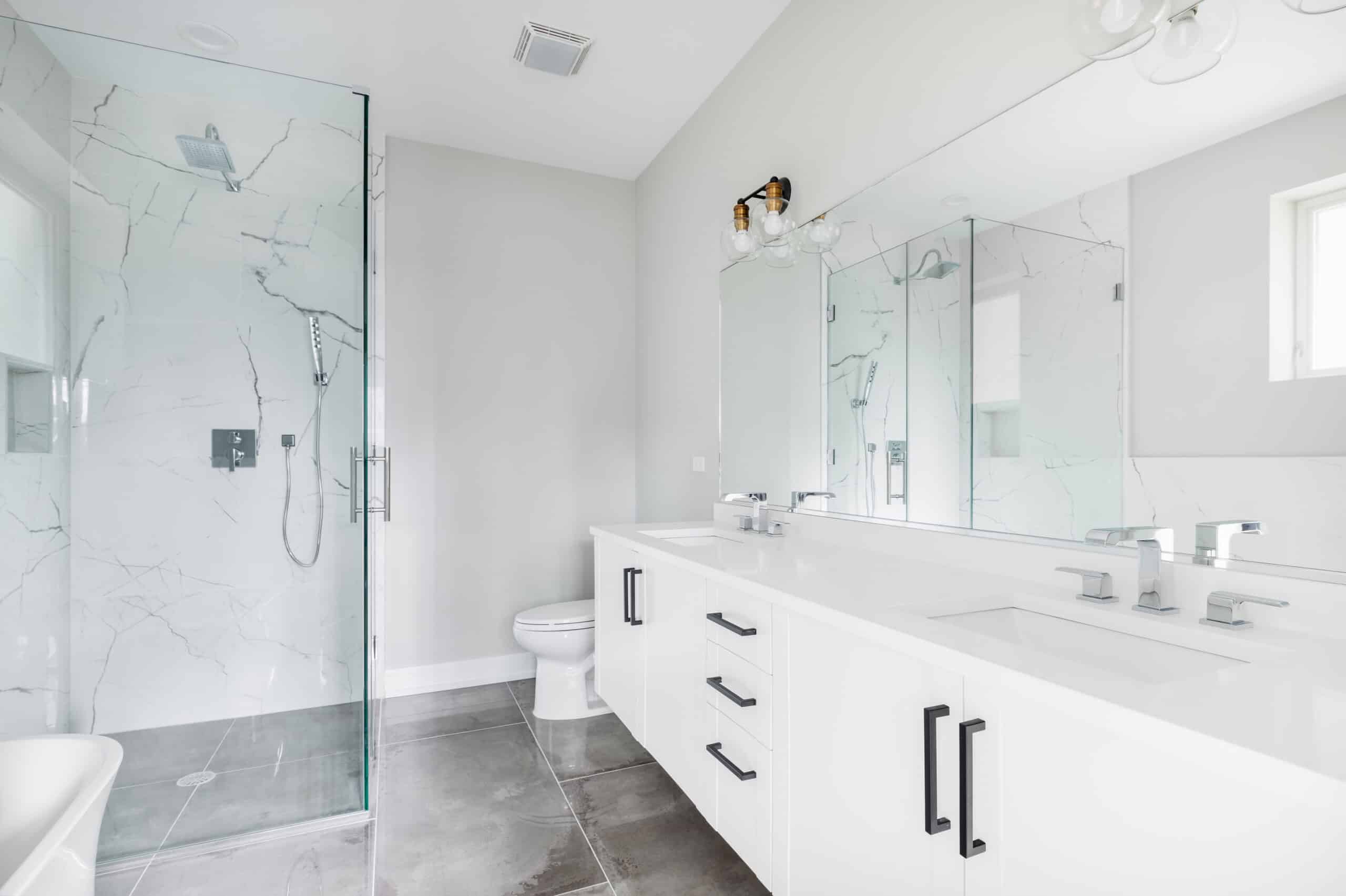 A modern, white luxury bathroom with black hardware and chrome f