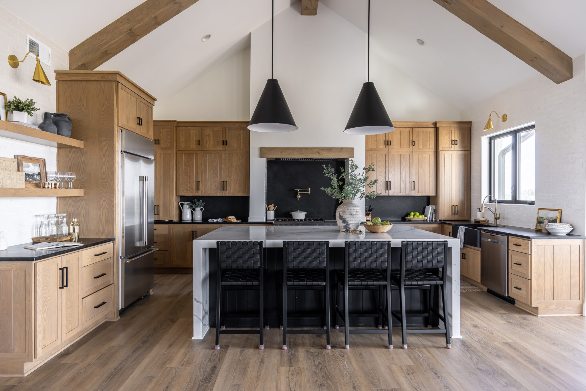 Classic Farmhouse kitchen style with light brown cabinets and black countertop, and white kitchen island
