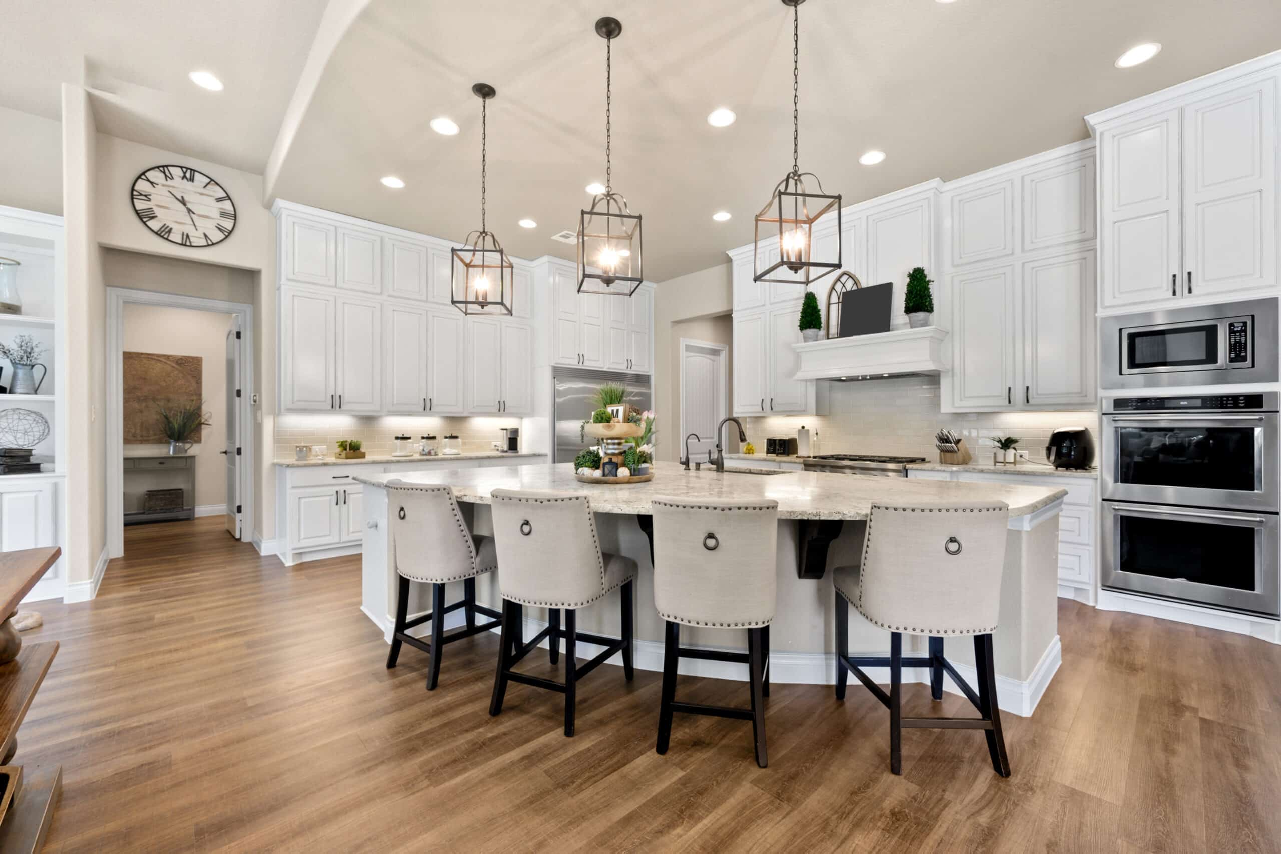 Spacious white kitchen style with curved kitchen island, and transitional kitchen cabinets