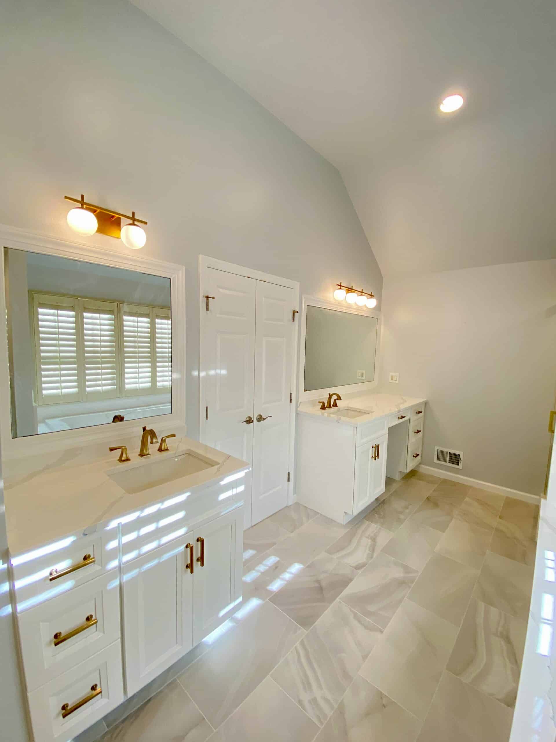 bathroom design showing 2 single sink white vanities with great lighting
