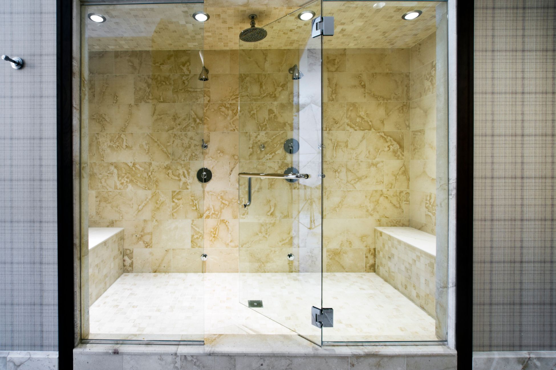 Spacious waterfall shower with cream wall tiles and white flooring