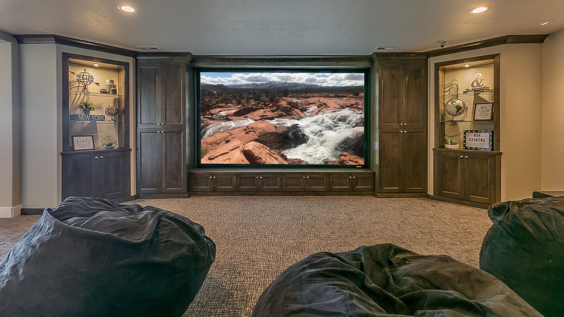 Basement Theatre room with carpet flooring, big brown cabinet with widescreen TV, and couch