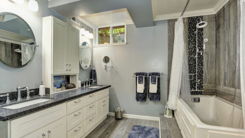 Basement bathroom with shaker white cabinet and black countertop