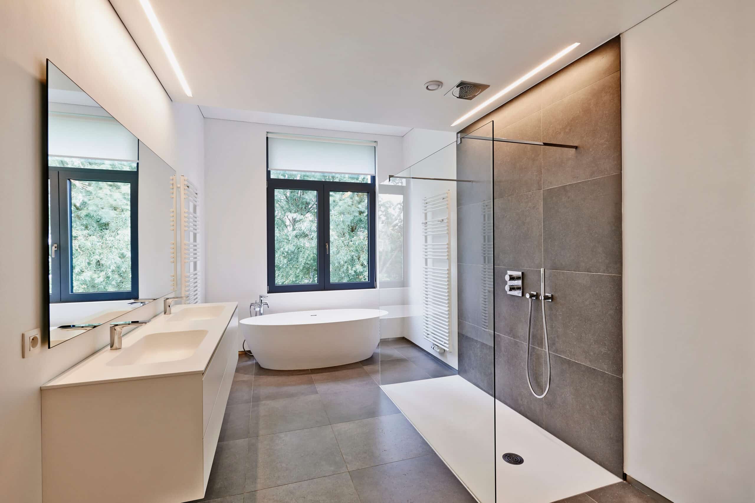 Spacious white bathroom with grey tiles wall and white flooring waterfall shower and bath tub