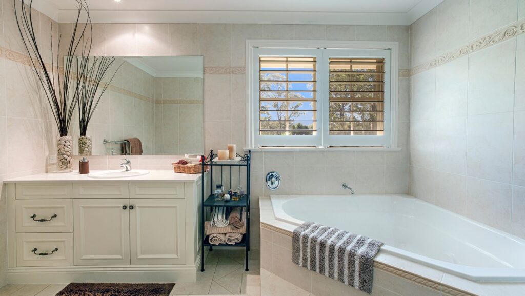 Clean white bathroom style with white transitional bathroom cabinets, and bath tub