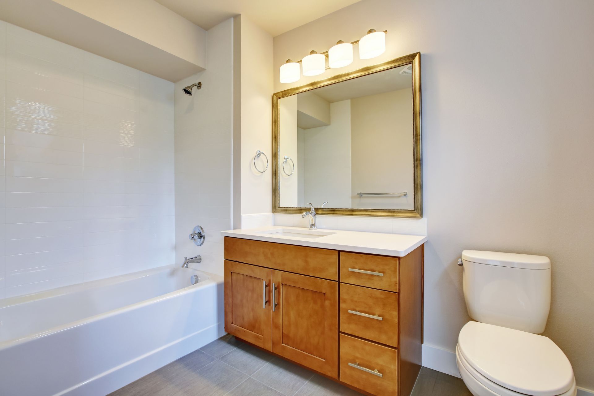 White bathroom with toilet, bath tub, and a classic oak free-standing vanity