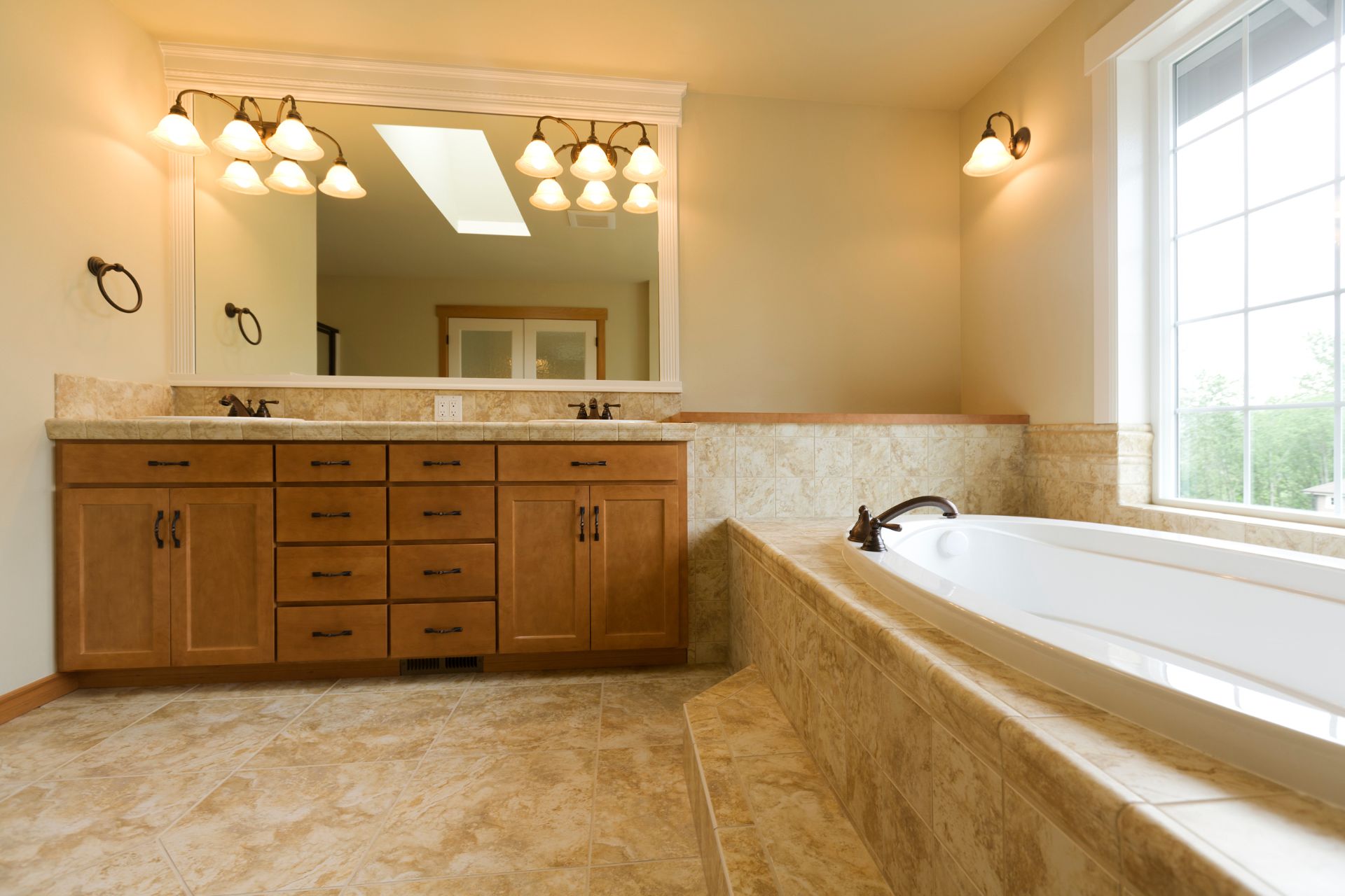 Brown bathroom design with wood double-sink vanity, and a bath tub