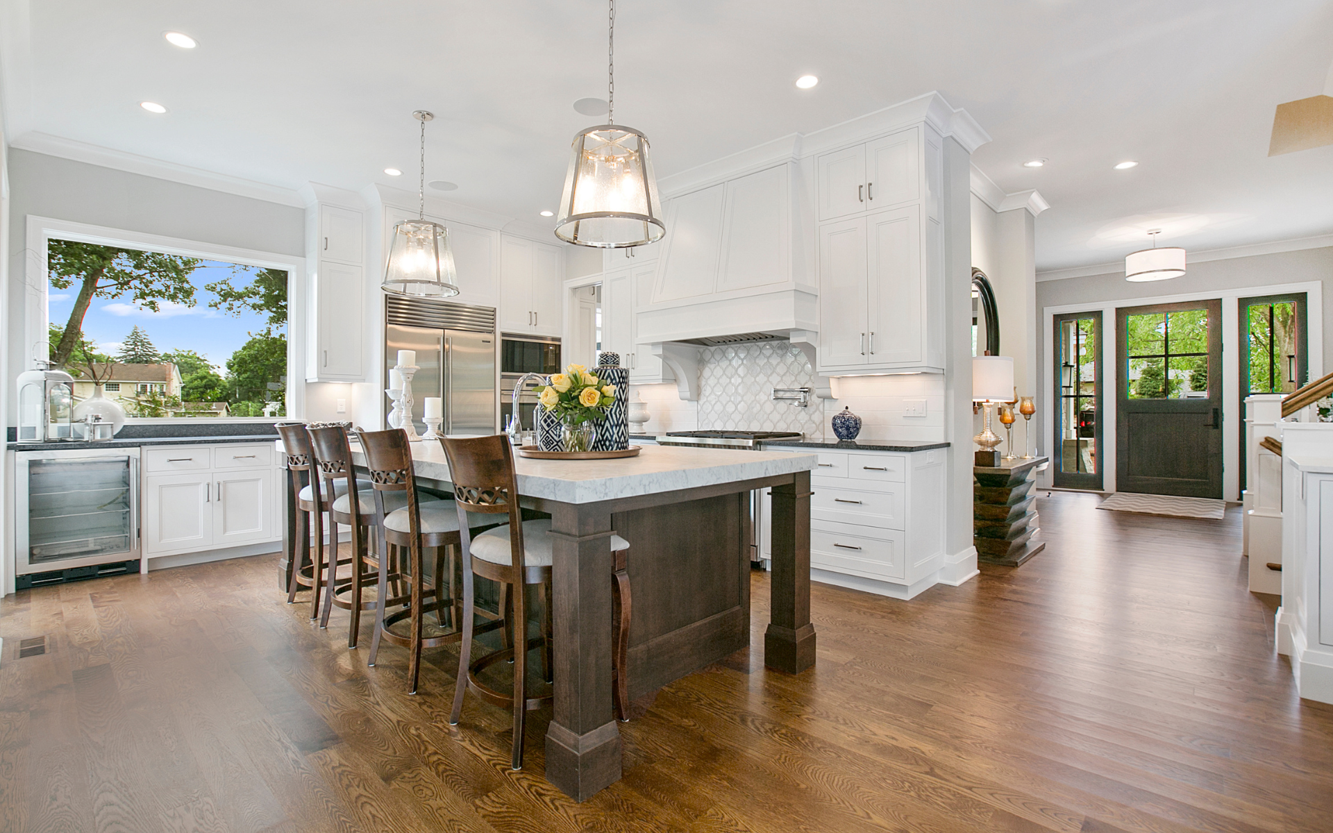Sleek kitchen style with white cabinets, and wood flooring