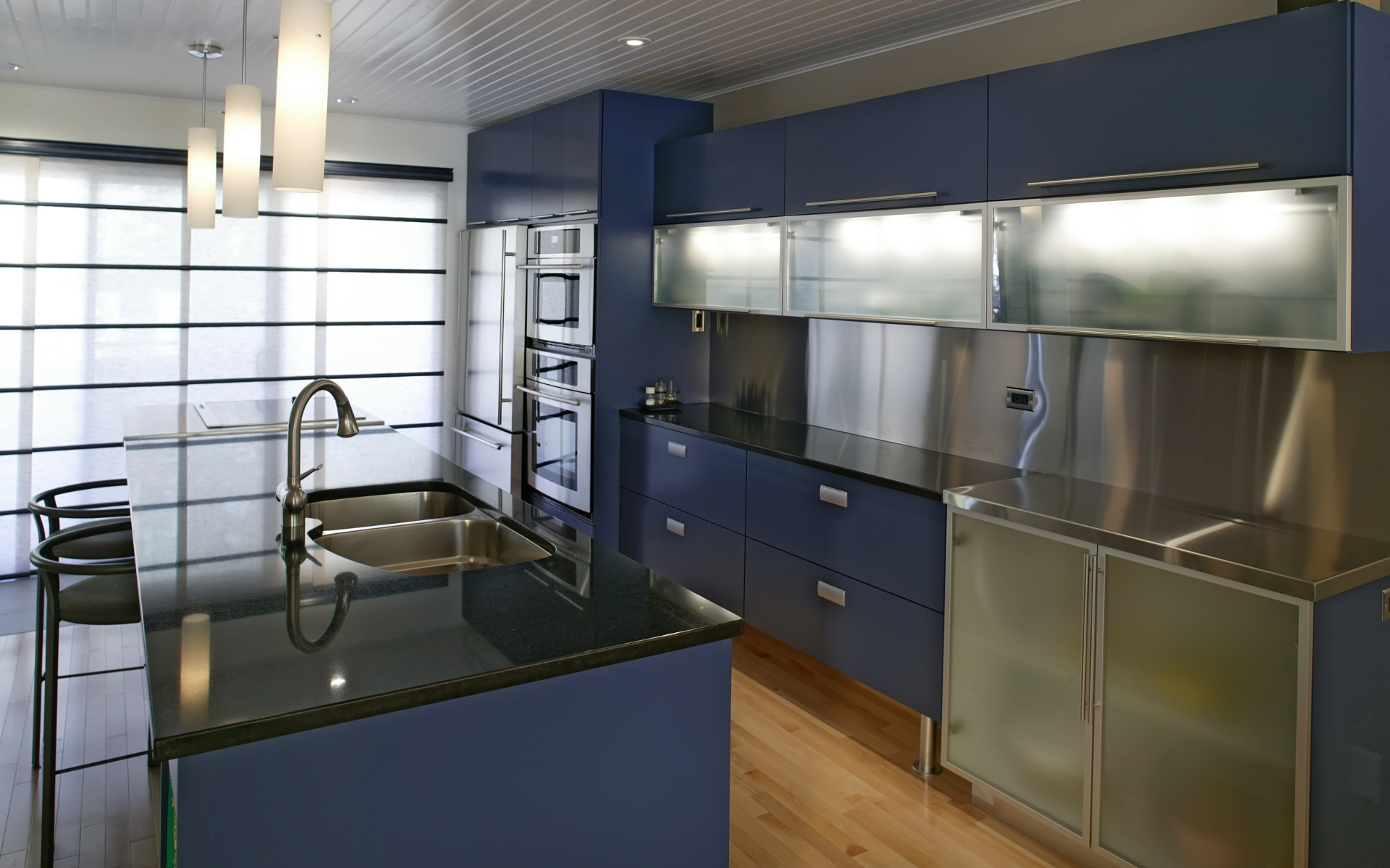 Contemporary kitchen with blue cabinets and black countertops