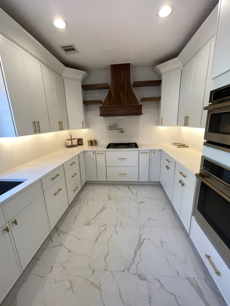 U-Shape kitchen with white slim shaker cabinets with gold hardwares, white quartz countertops and white floor tiles