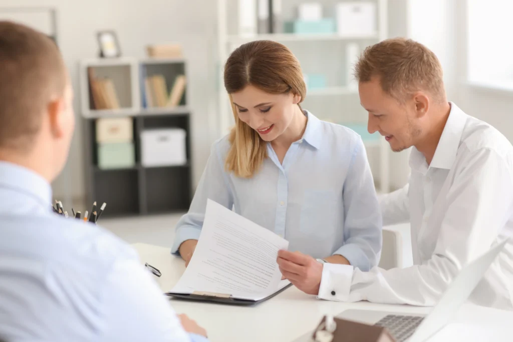 Couple reading contract and design with remodeling contractor