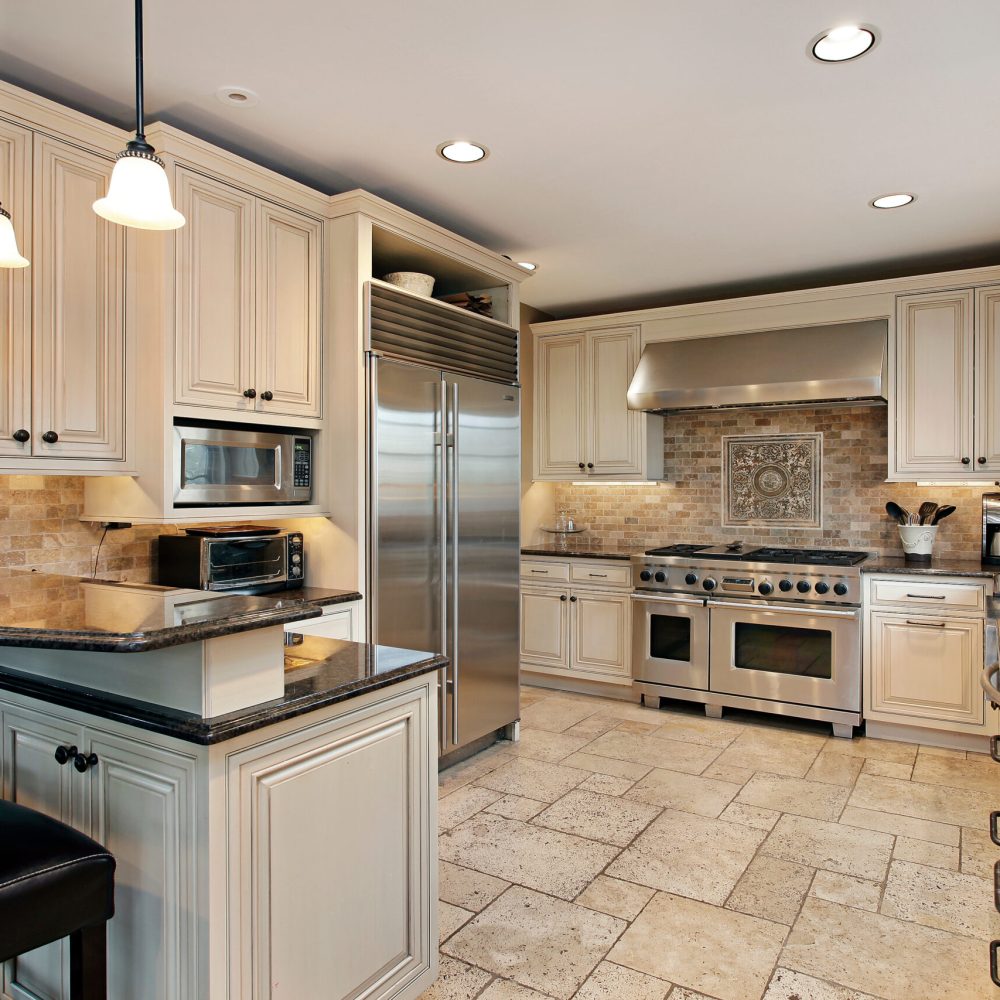 upscale luxury kitchen design with white cabinetry and black countertop