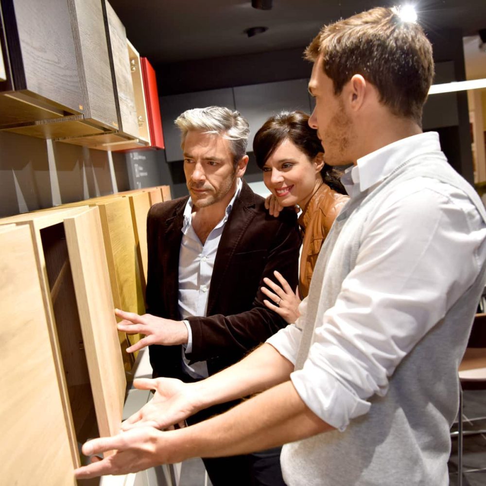 couple getting entertained by showroom designer on choosing cabinet doors